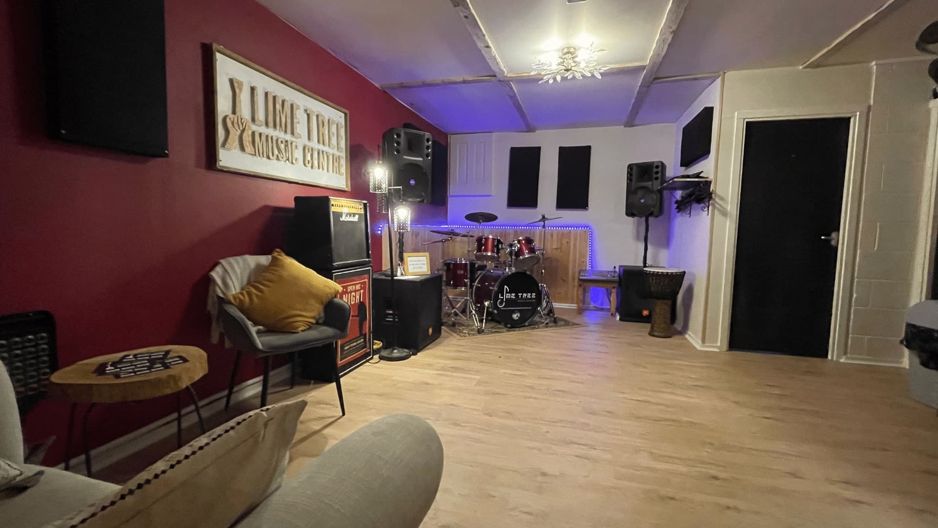The seating area in the rehearsal room, with the drum kit and amps behind